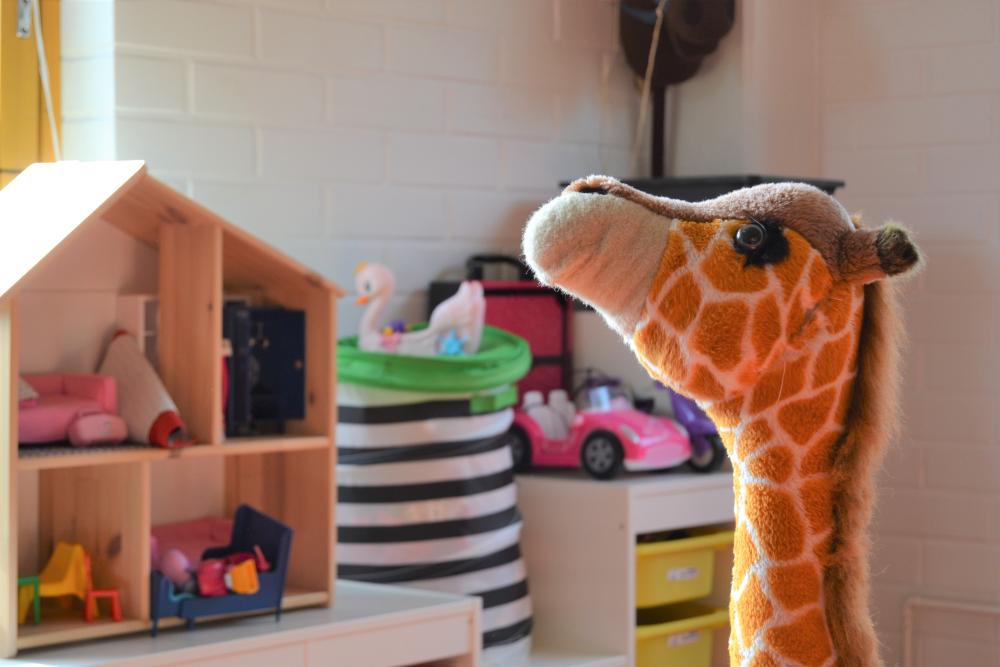 Kuva päiväkerhon tiloista jossa leluja ja iso kirahvi